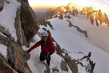 Tommy am Zustieg des Dent du Géant vor dem im Sonnenaufgang glühenden Mont Blanc